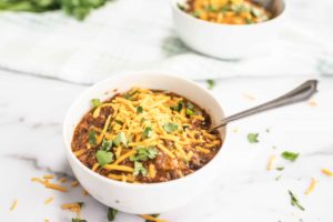 Three Cheese Black Bean Chili in a bowl topped with cheese and green onions