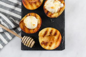 Grilled Peaches and Cream Gelato is scopped into actual grilled peaches and has caramel drizzled on top