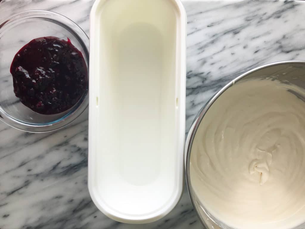 a bowl of cream, a plastic container and a jar of jam