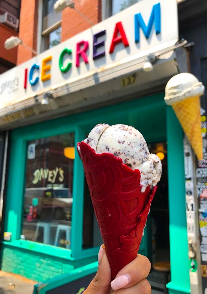 a red ice cream cone held in front of a sign that says "ice cream"