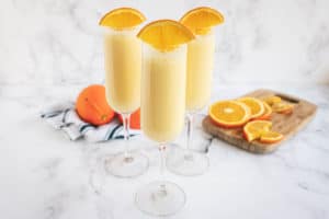 Orange Creamsicle Mimosas in champagne glasses with orange slices on the rims