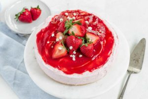 a cheesecake is topped with strawberry sauce and strawberries