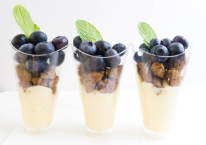 Lactose-Free Blueberry Vanilla Custard Parfait in a clear glass garnished with a mint leaf