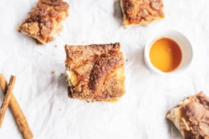 Mexican Cheesecake Bars with cinnamon sticks on the side