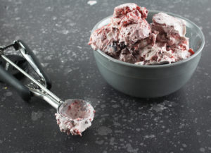 Very Cherry Gelato in a dish with an ice cream scoop on the side
