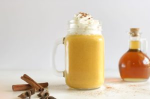 Pumpkin Spice Smoothie in a mason jar with a handle and topped with whipped cream