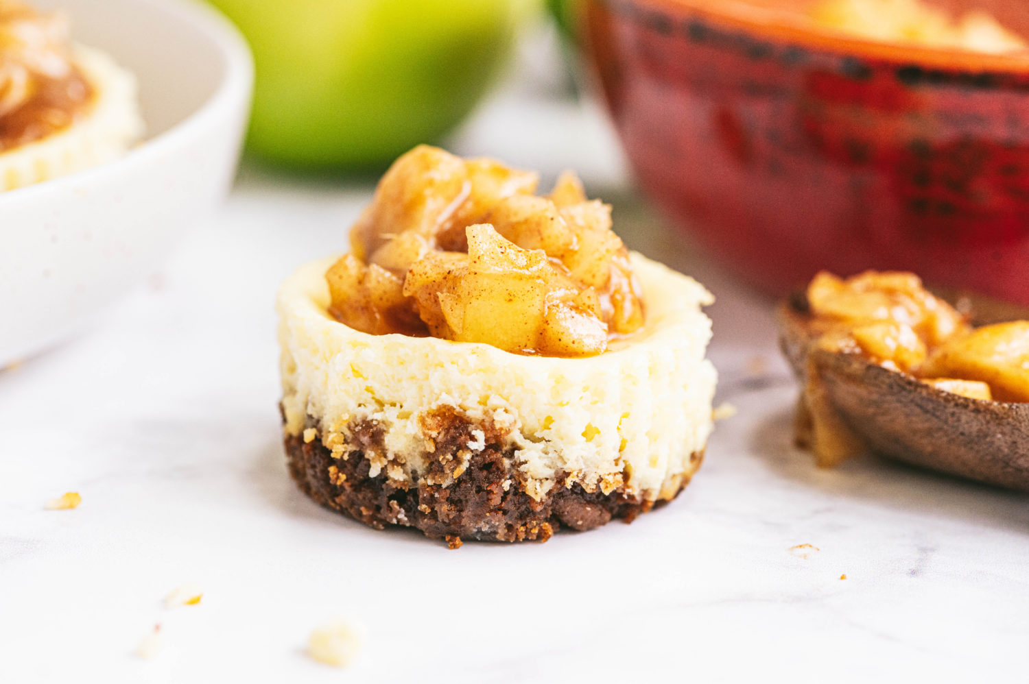 spiced apple cheesecake bite is pictured topped with cinnamon apples