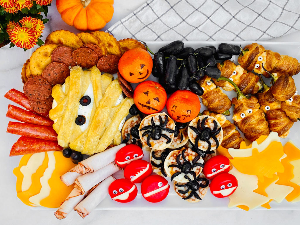 Stylish white tray adorned with scary Halloween food, showcasing a perfect blend of spooky and delicious treats.