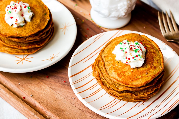 gingerbread pancake stacks topped with whipped cream and red and green sprinkles