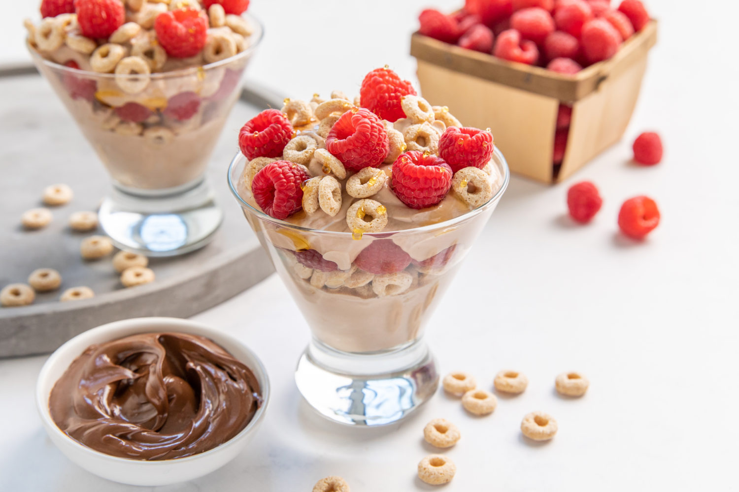 nutella raspberry parfait with raspberries and cheerios on top