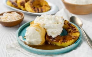 Grilled Pineapple Sundae on a blue plate with whipped cream on top