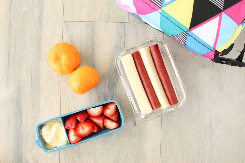 On-the-go Snacks - From left to right: clementines, strawberries with yogurt and honey, mozzarella sticks and turkey jerky.