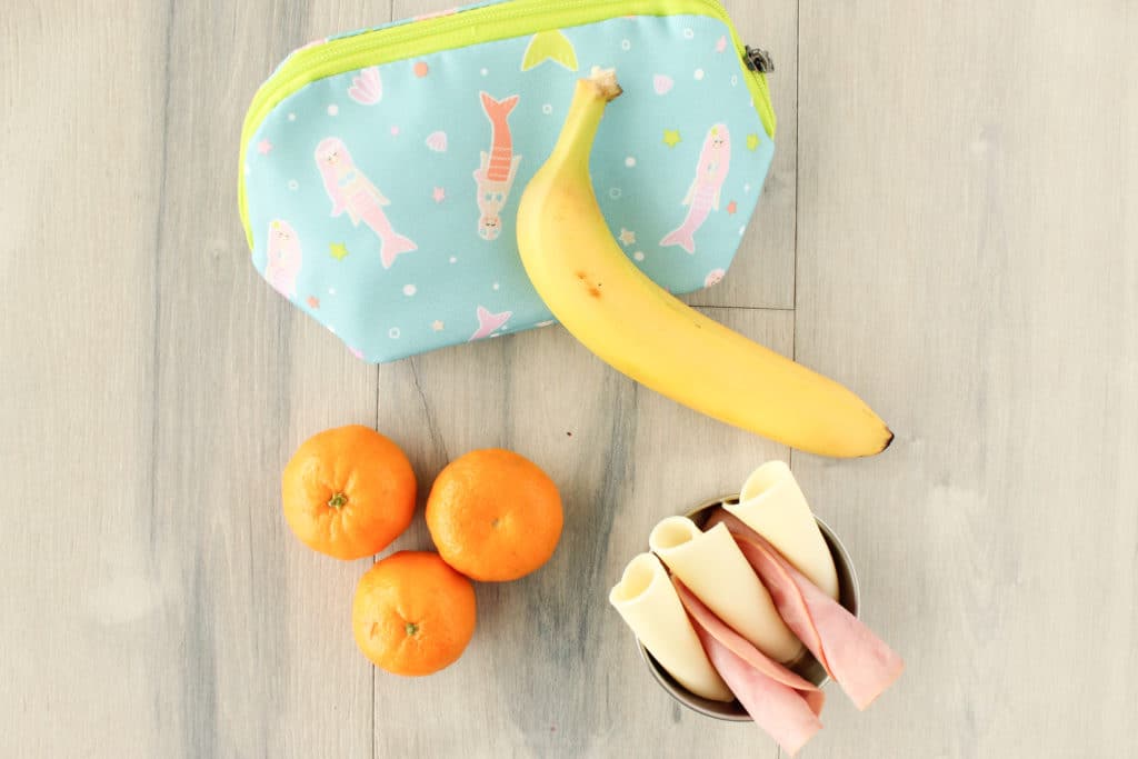 Kids' on-the-go snacks - From left to right: clementines, provolone cheese and honey ham, and a banana.