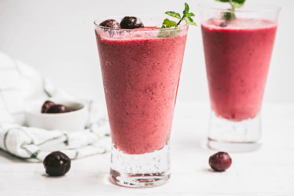 cherry smoothie garnished with cherries and mint leaves