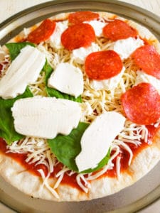 A pizza topped with various ingredients, prepared and awaiting baking.