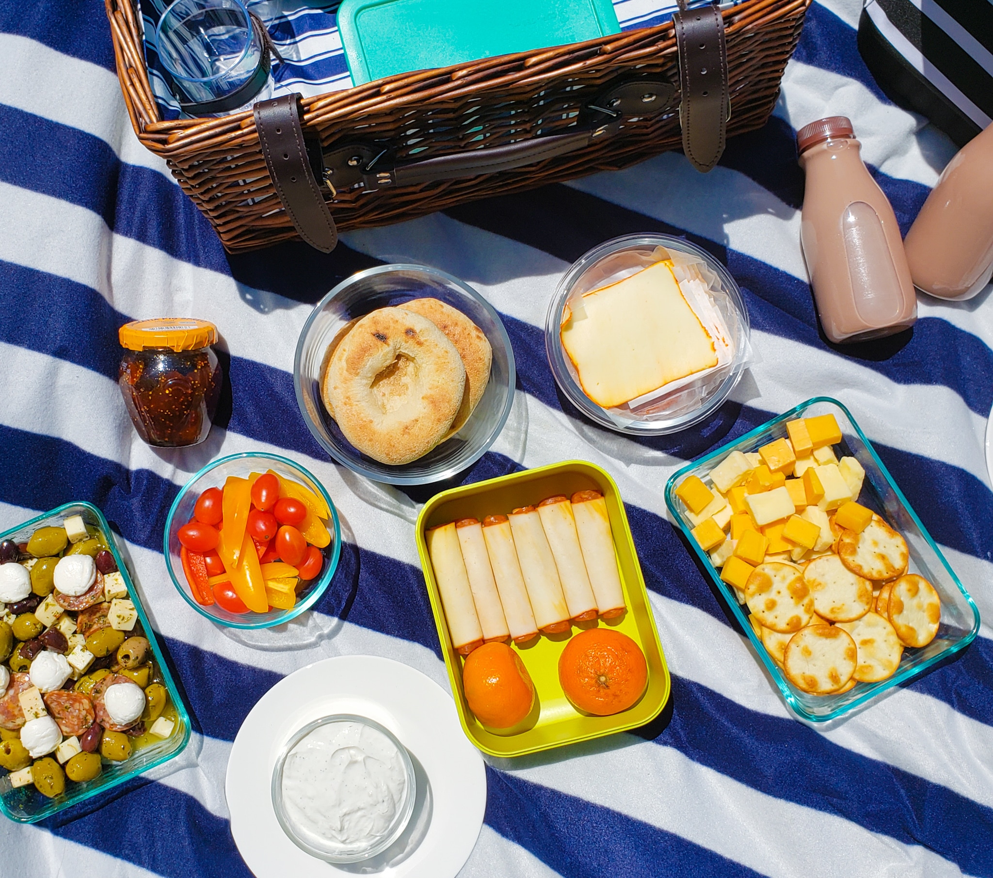 dishes of foods spread out on a picnic blanket