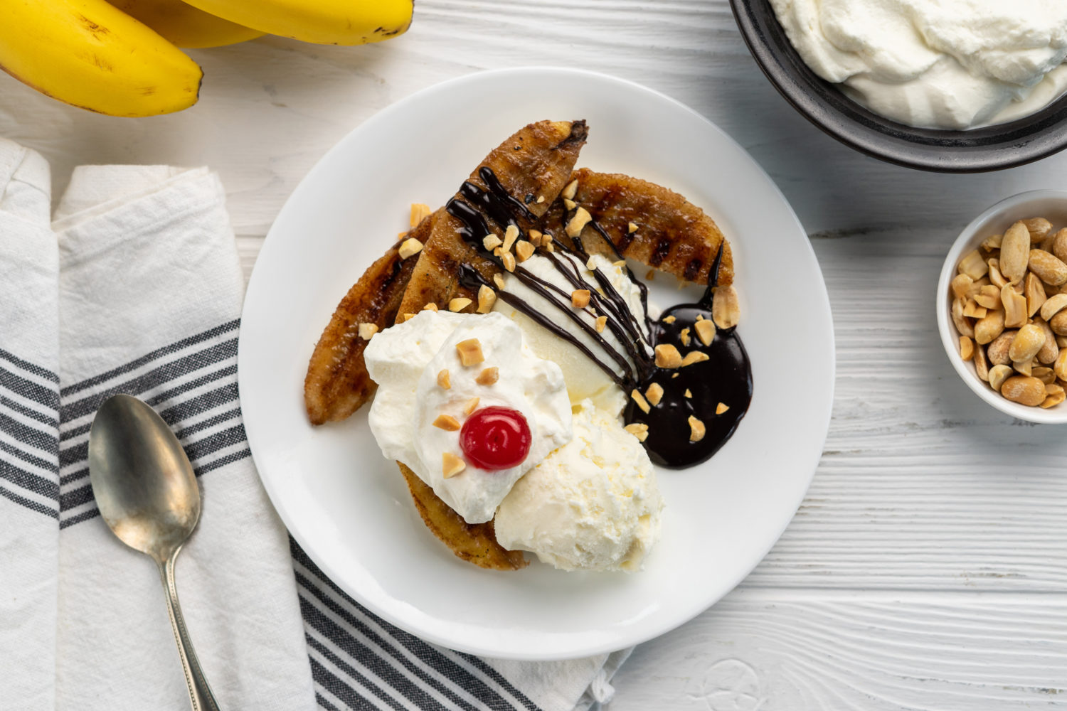 grilled bananas with ice cream, chocolate syrup and whipped cream
