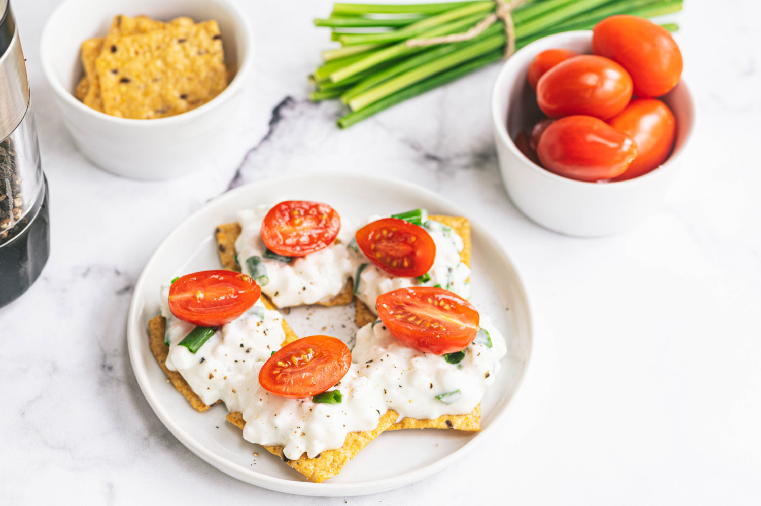 crackers topped with cottage cheese and tomatoes