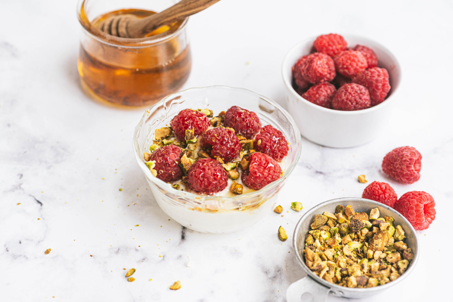 ricotta cheese in a bowl topped with granola and raspberries