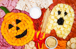 halloween snack board with meat and cheese in the shape of a jack-o-lantern and a ghost
