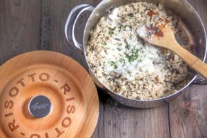mushroom risotto in a beautiful dish that has a wooden lid that says "risotto"