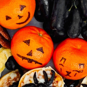 Mandarins decorated with black marker to look like a jack-o-lantern.