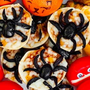 Spooky Halloween spider pies and other festive snacks in the background.