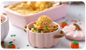 Small pumpkin-shaped bowl with pumpkin gingersnap ice cream and colorful sprinkles.