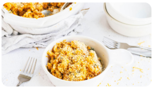 Delicious pumpkin mac and cheese served in a white bowl, sprinkled with breadcrumbs over the top.