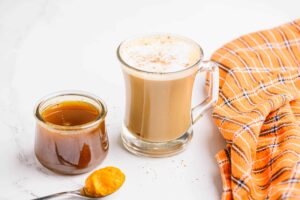 Un café con leche de calabaza recién preparado servido en una taza transparente.